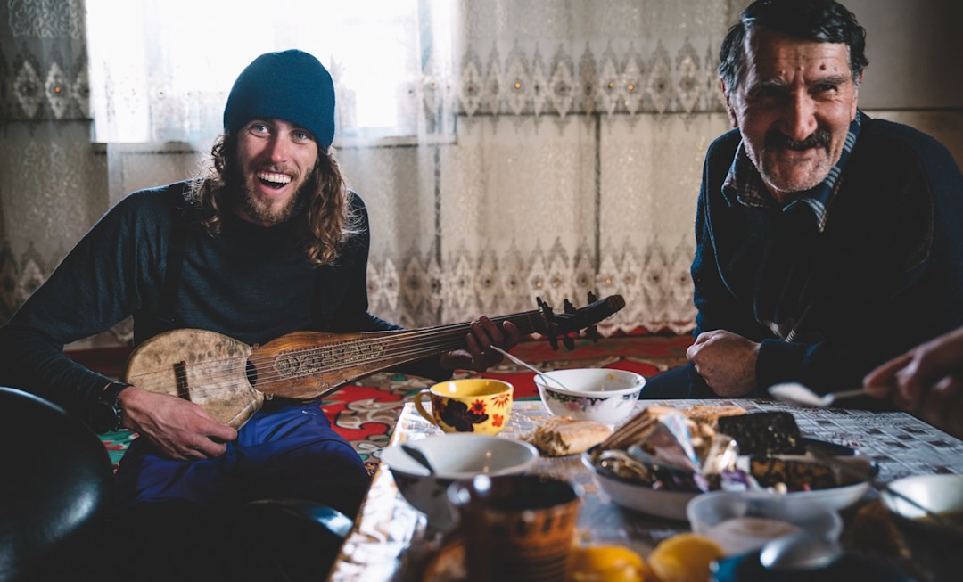 A warm welcome in a remote world, Jackson plays music and shares stories with a Kyrgyzstani local.