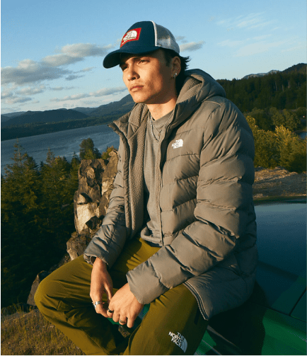 A man rests near a scenic overlook in a jacket from The North Face