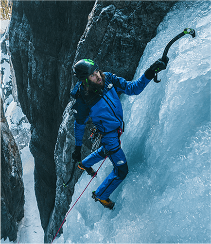 A man scaling a wall in gear from The North Face
