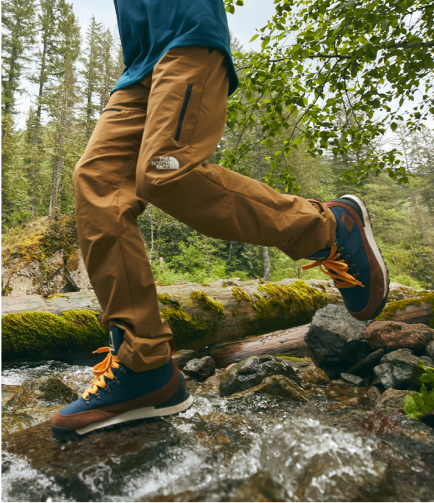 A man walks through a forest in hiking pants from The North Face