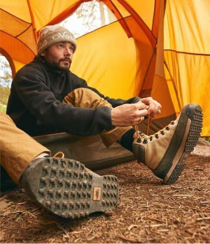 Man pictured in his tent lacing up his The North Face boots