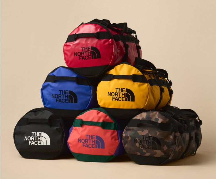 Several Base Camp Duffels in various colors stacked in a pyramid. 