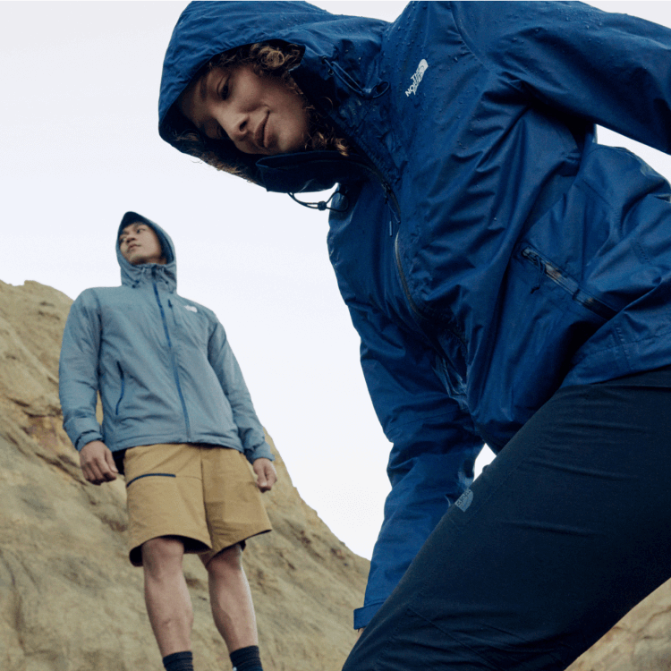 Woman wearing the Daybreak Parka standing in the rain with the city in the background.