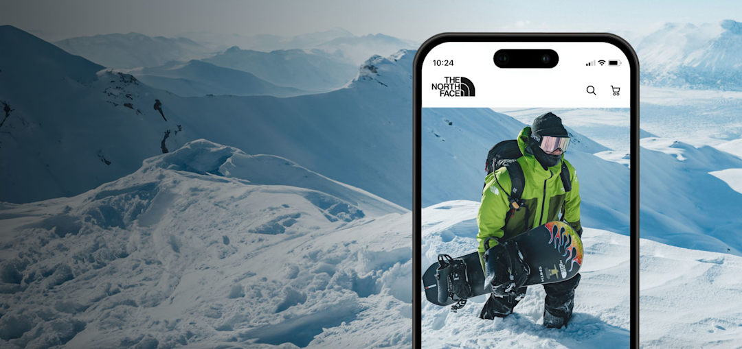 Imagen de la pantalla de un teléfono celular que muestra a un snowboarder caminando por una montaña nevada.