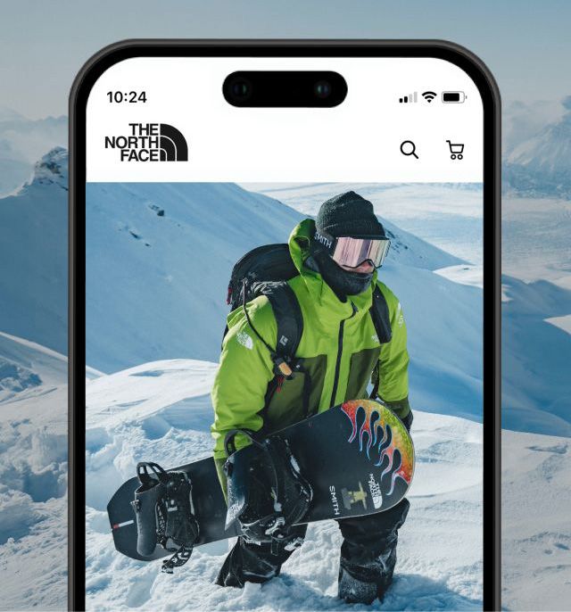 Imagen de la pantalla de un teléfono celular que muestra a un snowboarder caminando por una montaña nevada.