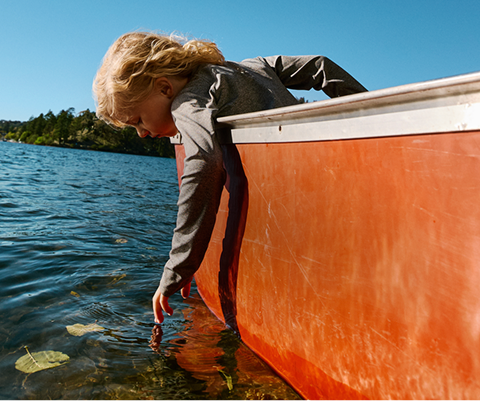 A boy canoes in his The North Face sun gear.  