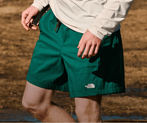 A man explores near the water in his The North Face shorts.