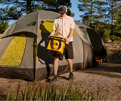 A man in front of his The North Face tent.