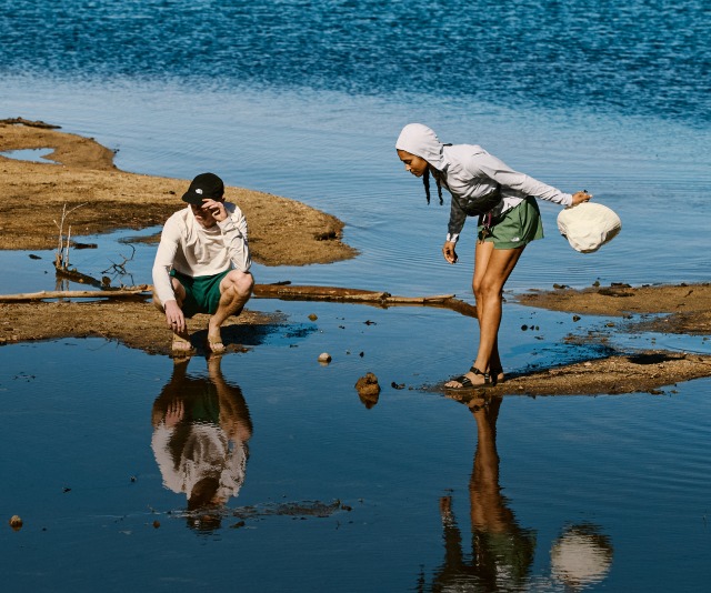A man and woman explore near the water in their The North Face sandals.