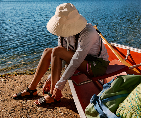 A woman puts on her The North Face sandals.