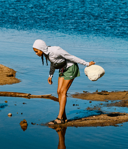 A woman looking down at her reflection in the water.