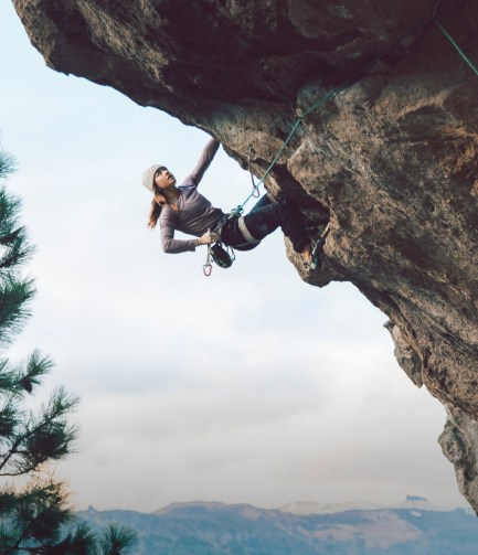 A woman climbing a rock wall.