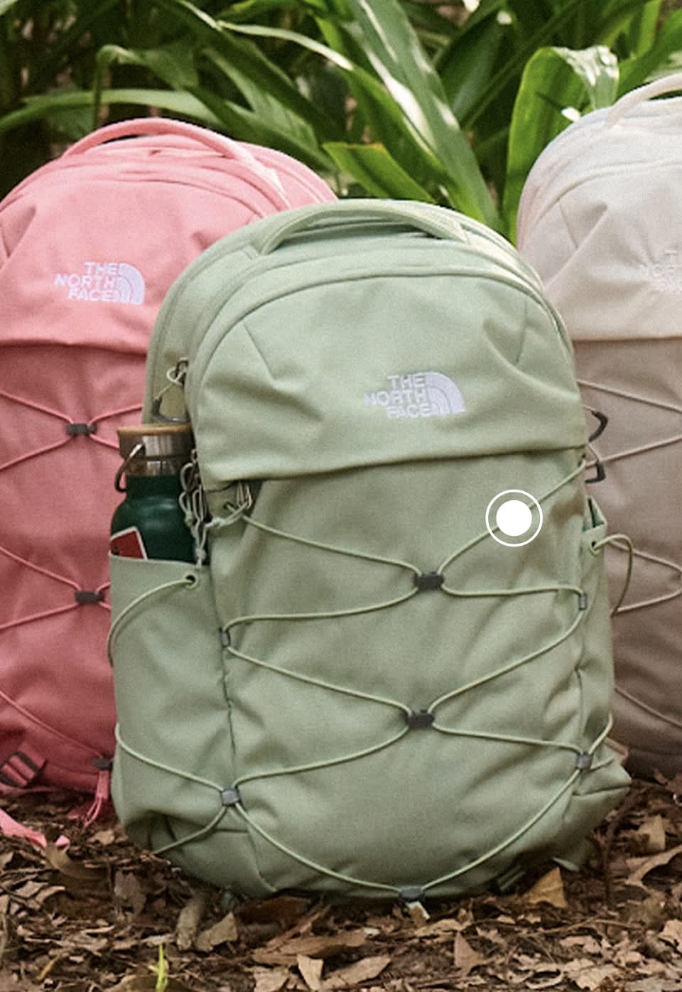 Five colorful Borealis backpacks sitting on the forest floor.