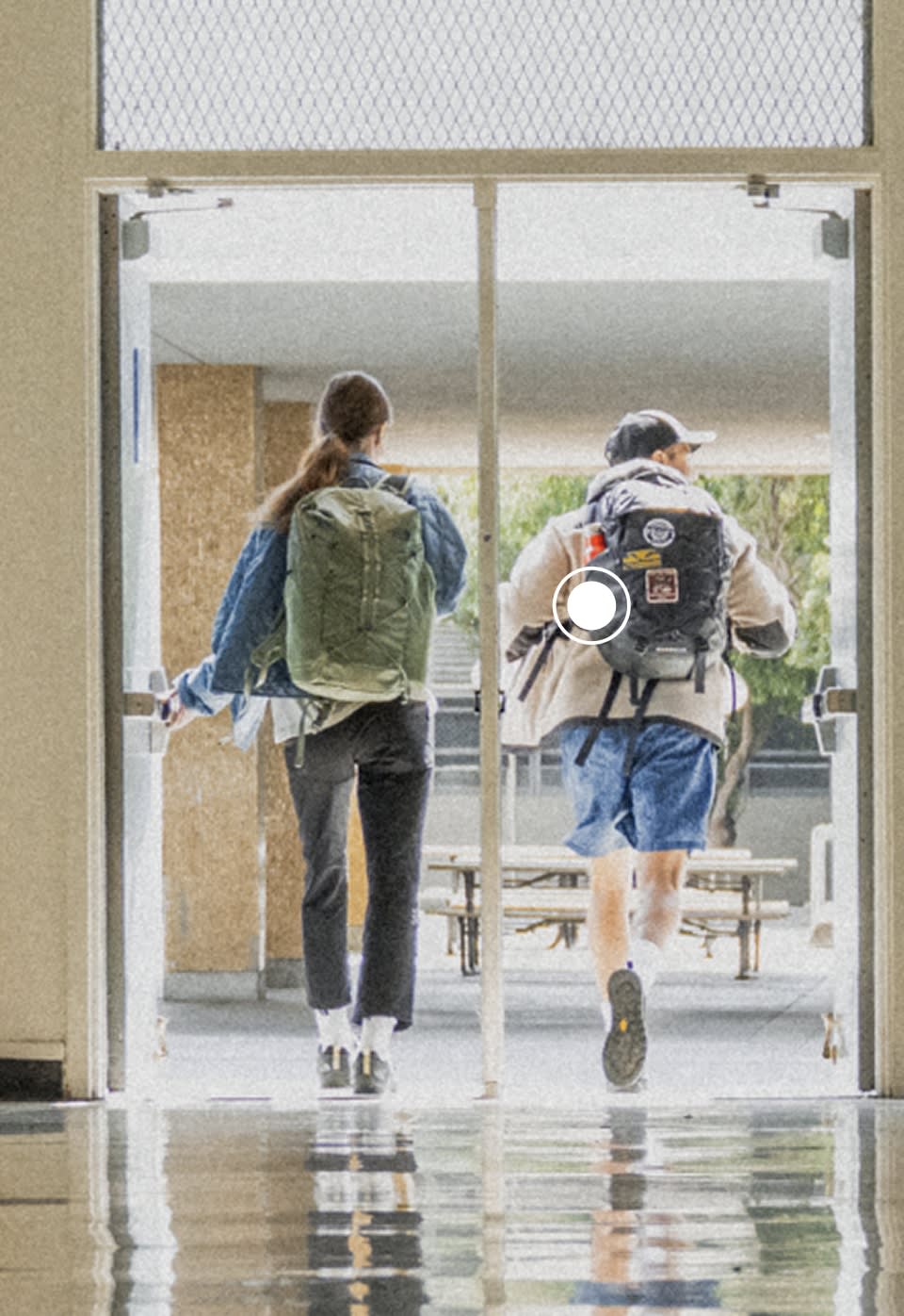 A boy wearing a black Borealis backpack from The North Face with patch details