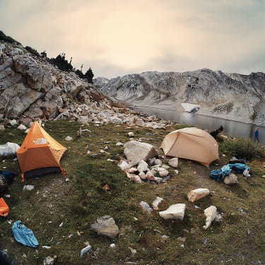 A group of campers set up their The North Face tents by a lake.
