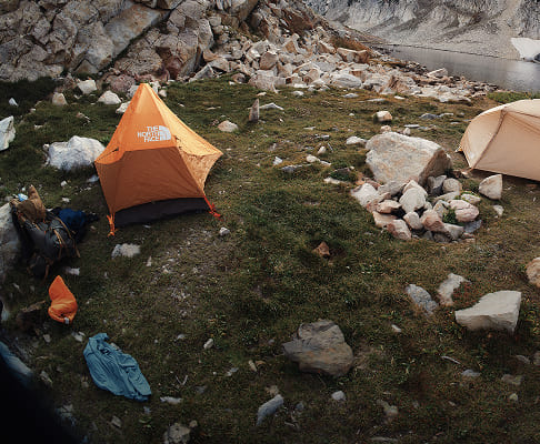 A group of campers set up their The North Face tents by a lake. 