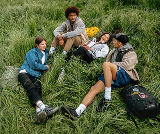 Students lay in grass in The North Face gear.