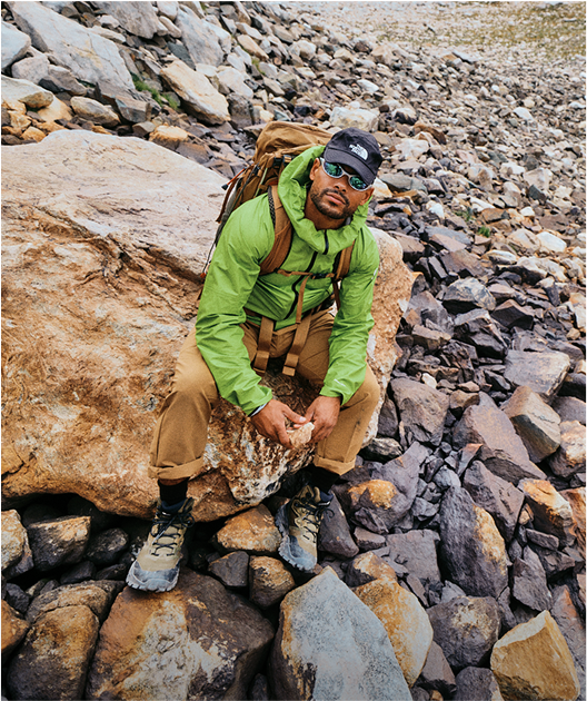 A hiker in The North Face gear sits on a rock.
