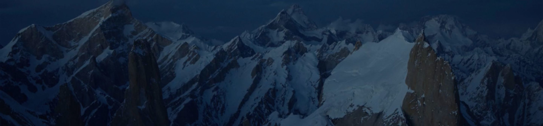Snowy peaks with a dark sky.