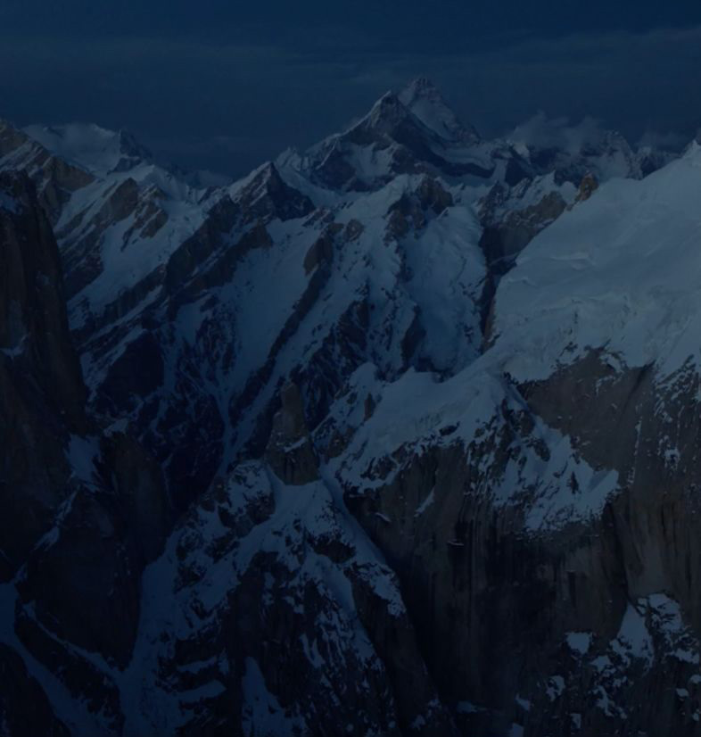 Snowy peaks with a dark sky.