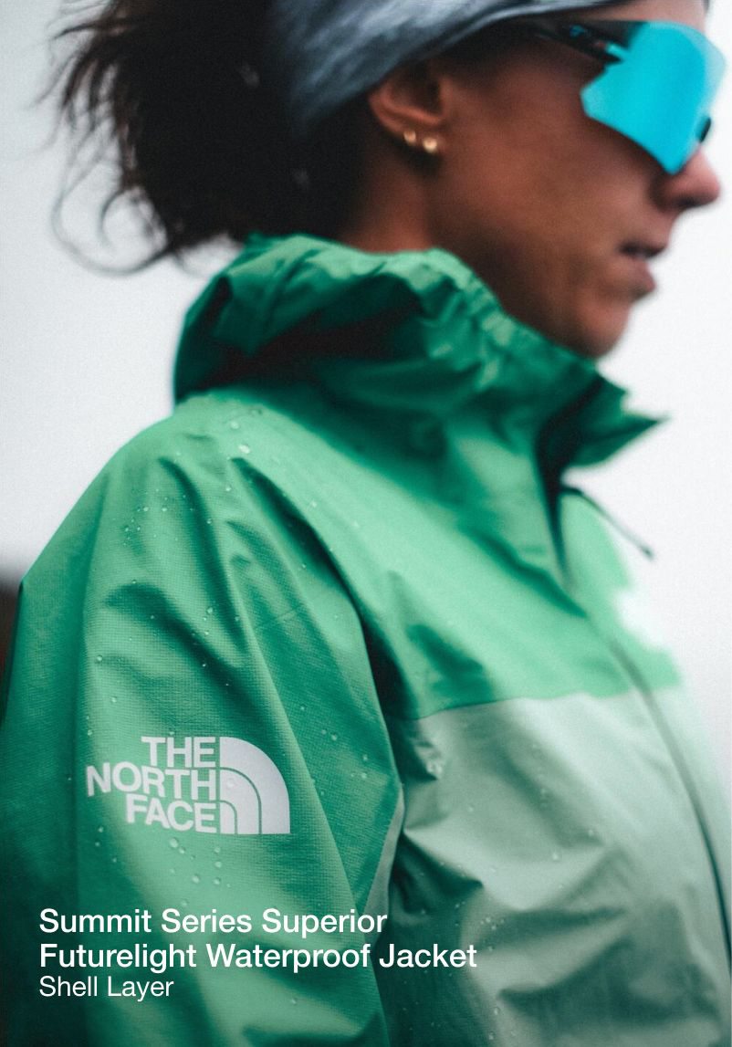 The upper half of Tara’s side profile in a turquiose jacket. The North Face logo is in focus. 
