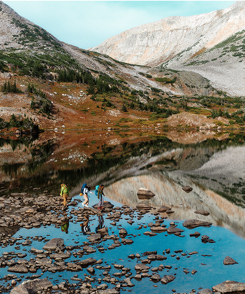 A group of hikers traverse a mountain vista wearing The North Face hiking gear.