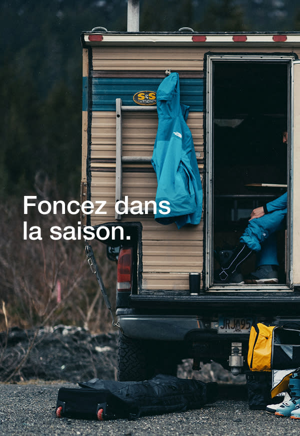 wo people walk toward the slopes, carrying The North Face Base Camp Boot Pack in Summit Gold and Base Camp Snow Roller.