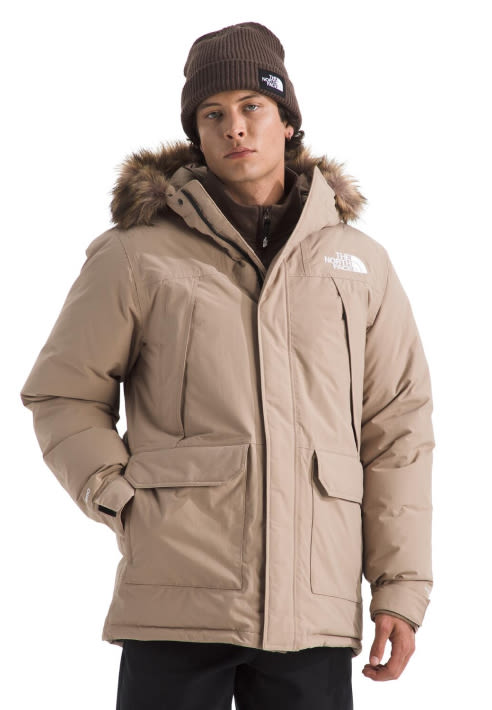 A guy in a tan McMurdo Parka with a brown beanie on.