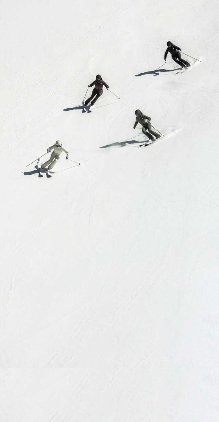 A group of skiers in The North Face x SKIMS collection.
