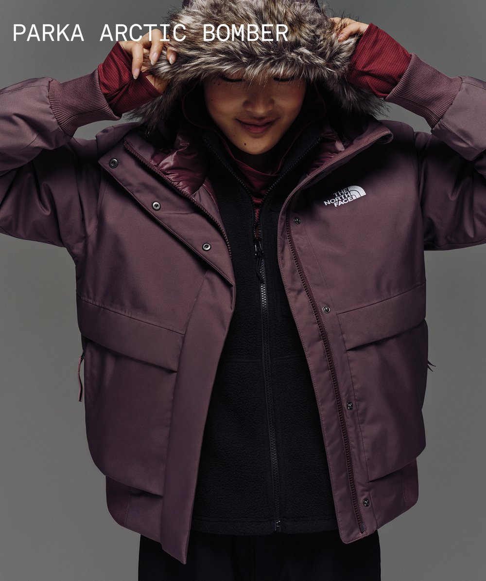 Une mannequin qui ajuste le capuchon du blouson Arctic dans la couleur quartz fauve. 