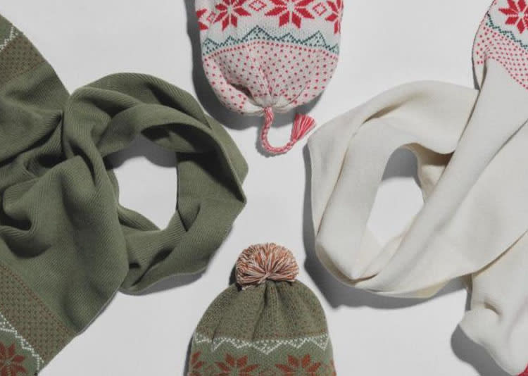 Green/red matching scarf and beanie next to a white/blue/red matching scarf and beanie. All have decorative snowflakes.