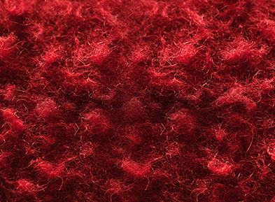 Gros plan sur un tissu de laine Casentino rouge à la texture rugueuse et floue.