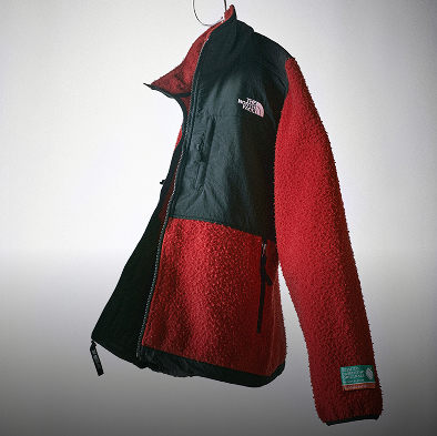 Gros plan sur la moitié inférieure d’une veste Casentino Denali par The North Face rouge et noire.