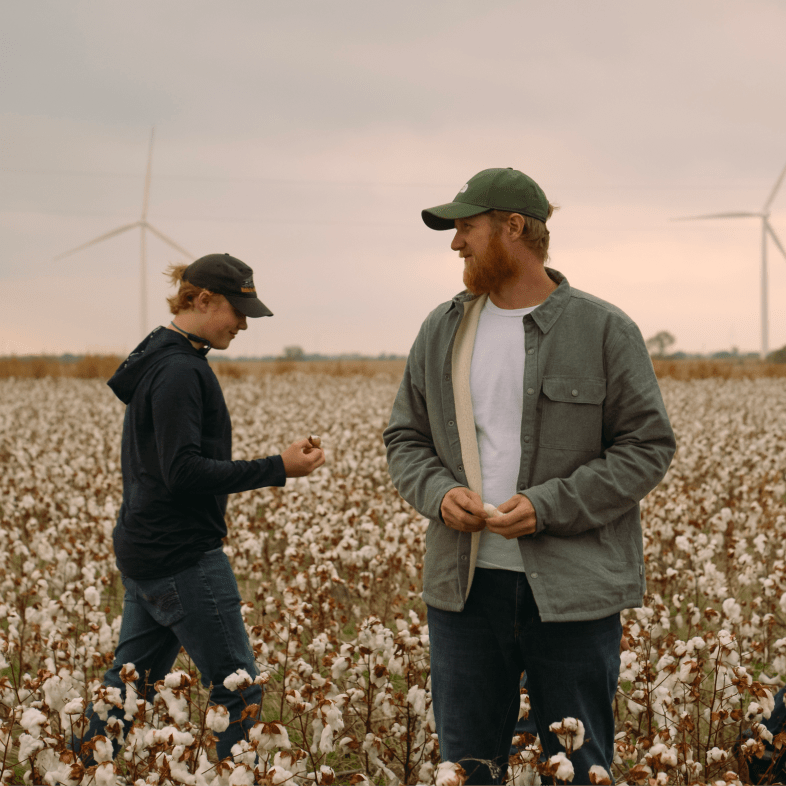 A hiker stands on a rock in front of a mountain.