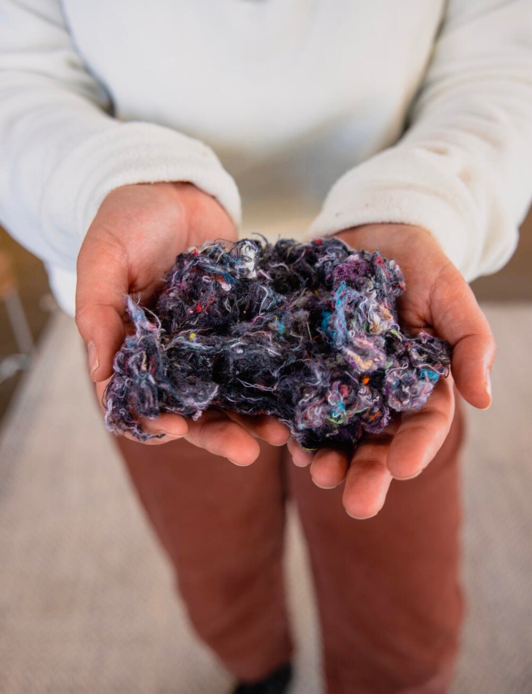 A person holding raw textile material