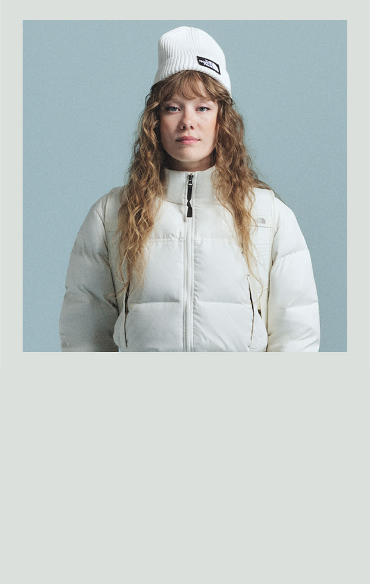 A man in a blue Nuptse all the way zipped, the image has a blue frame around it.