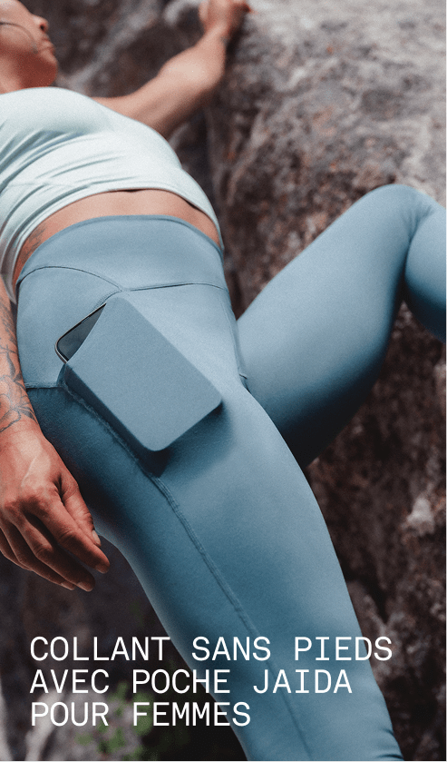 Un mannequin portant la camisole Jaida en givre opale et le legging à poches Jaida en gris granite, présenté contre une surface rocheuse.