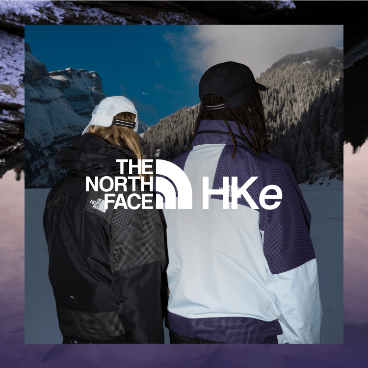 Man and woman in jackets face mountain. 