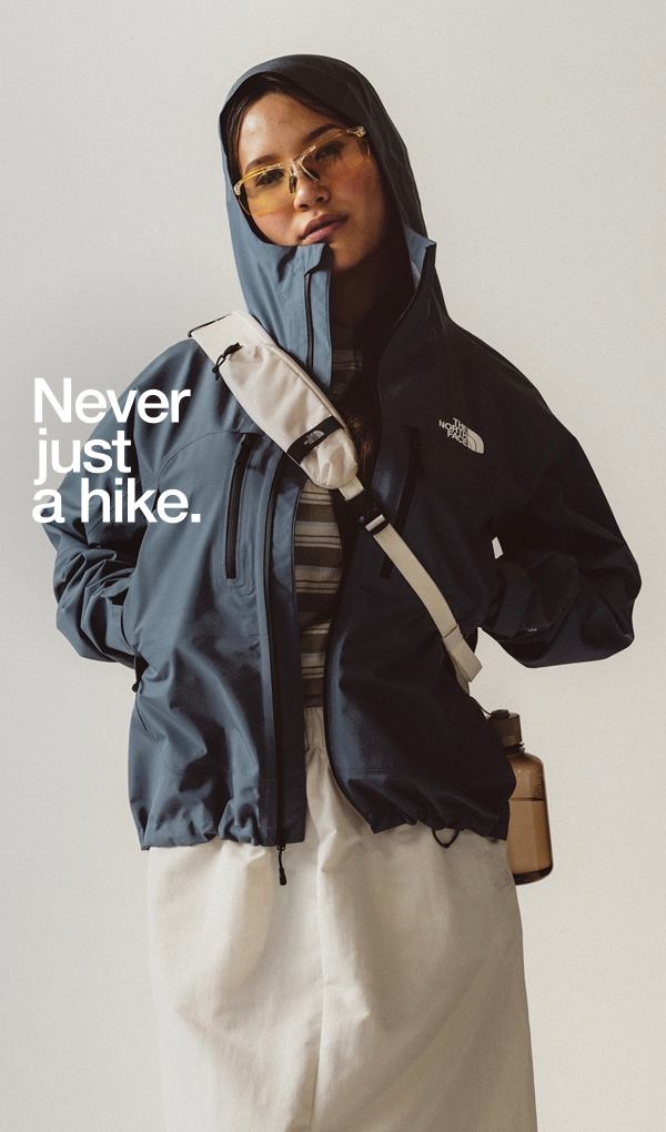 Woman wearing yellow sunglasses and blue rain jacket on white background. 