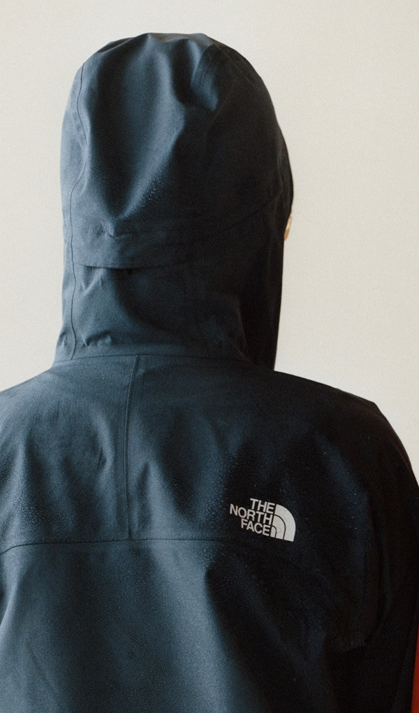 Woman facing away wearing blue rain jacket