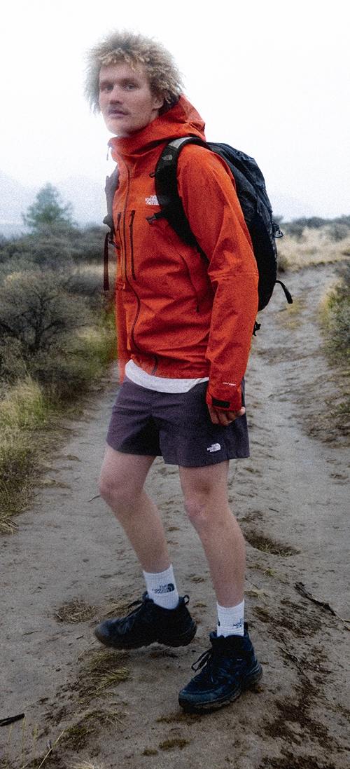 standing man wears red jacket. 