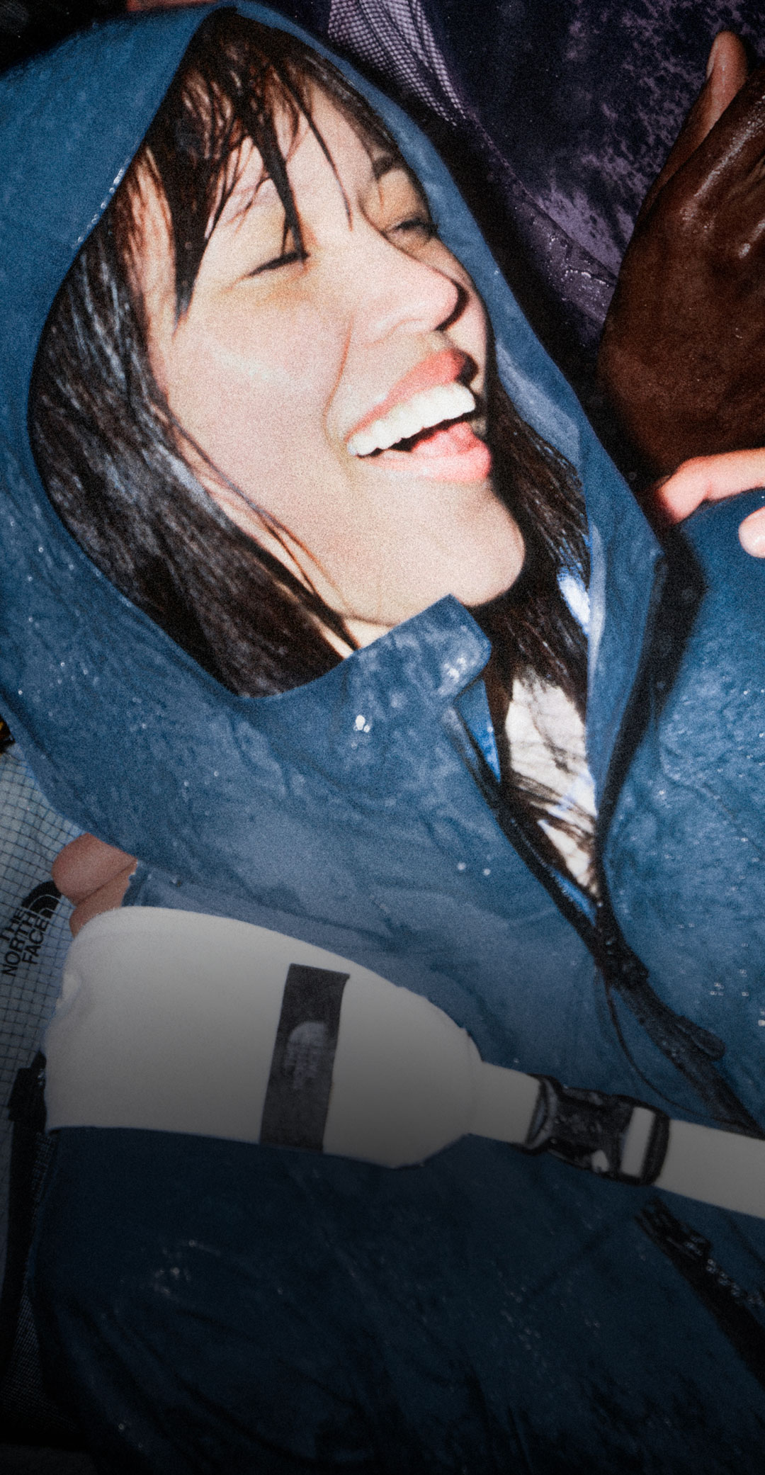 Woman wears blue jacket in crowd.