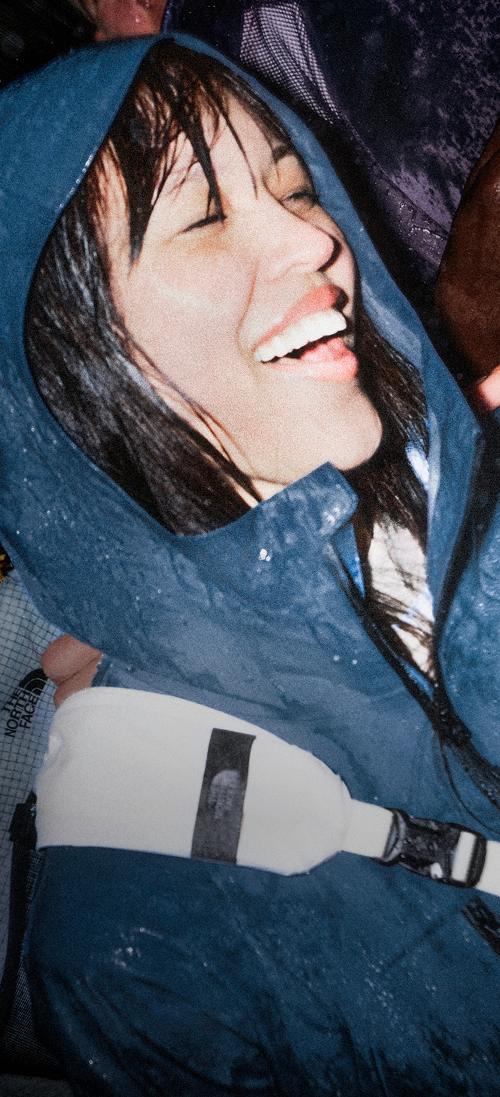 Woman wears blue jacket in crowd.