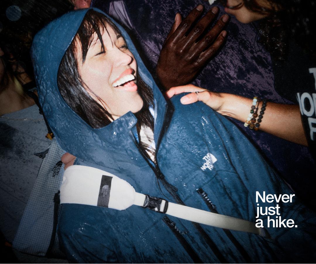 woman smiling wearing blue jacket in crowd. 