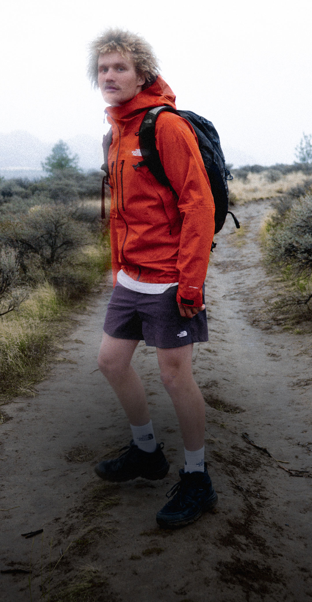 Guy wears red jacket on trail.