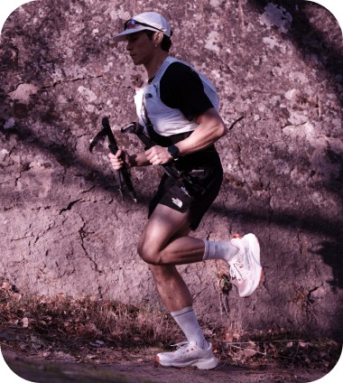 A person in a black shirt, white vest, and white cap with sunglasses running.