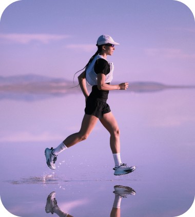 A person in a black shirt, white vest, and white cap with sunglasses running.