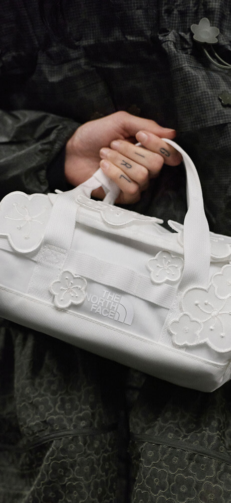 A model posing with a Anna Base Camp Duffel from The North Face x Cecilie Bahnsen collection 