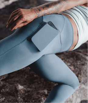 Person wearing blue leggings with a smartphone in the pocket. 