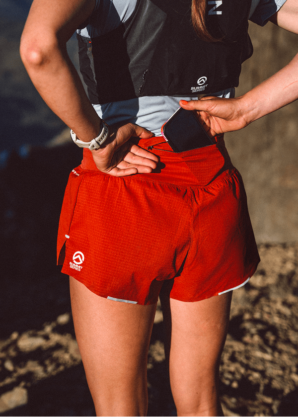 Woman putting phone in her shorts back pocket